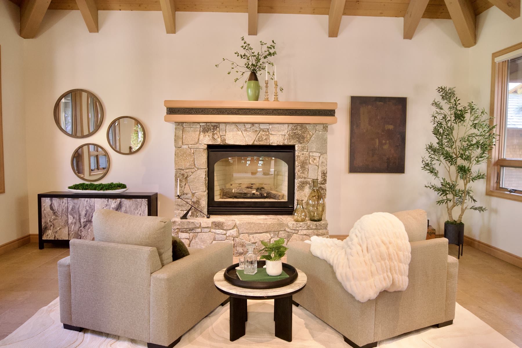 Staged sitting room with two armchairs facing a stone fireplace