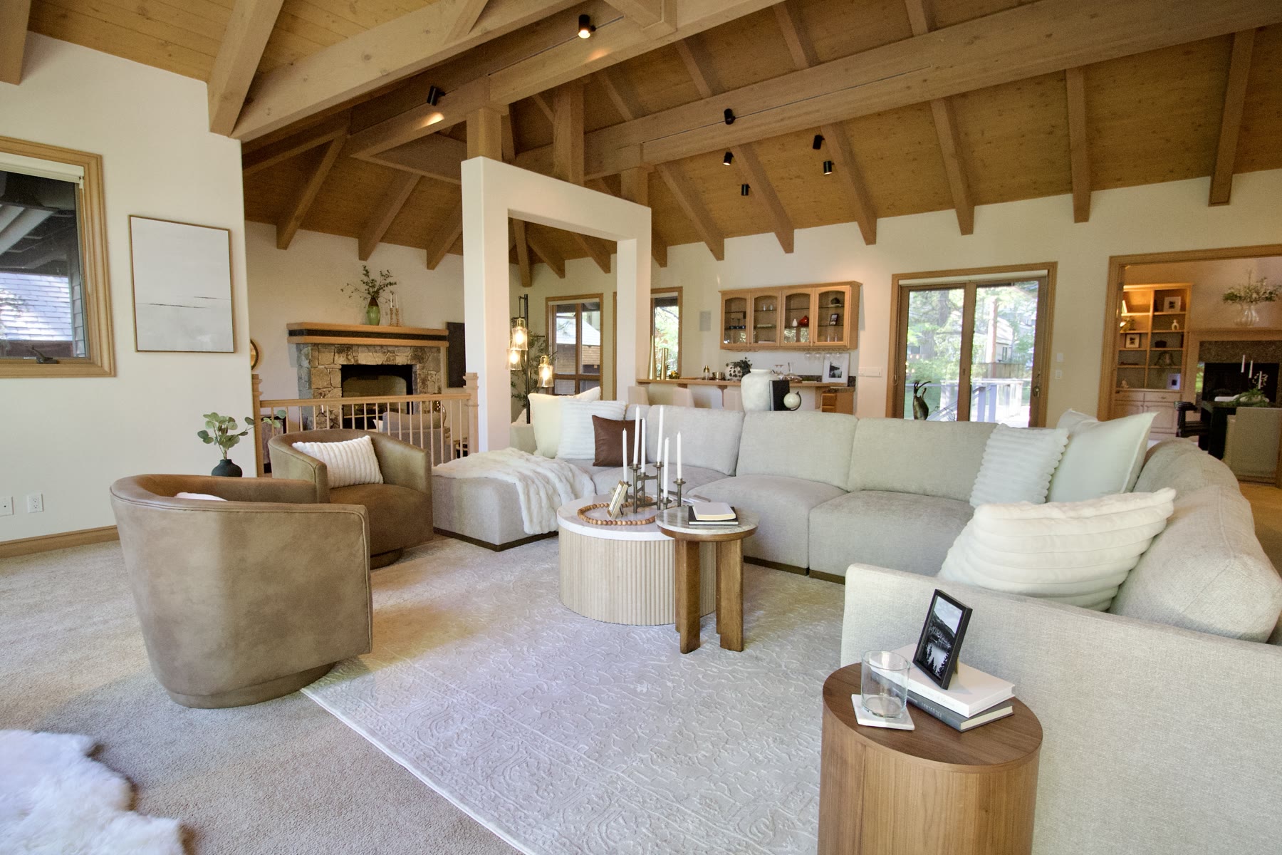 Staged great room seen from behind the sectional, with wood beams overhead